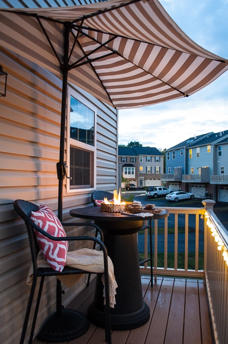 Fire pit surrounded by chairs on a small deck