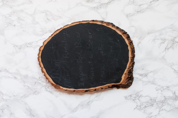 DIY tutorial for this pretty gather chalkboard wood slice sign. Easy way to create hand-lettered chalk designs.