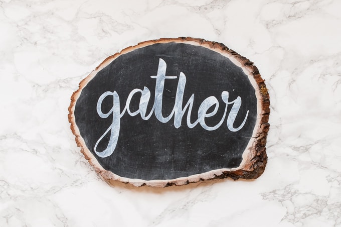 DIY tutorial for this pretty gather chalkboard wood slice sign. Easy way to create hand-lettered chalk designs.