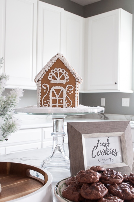 Modern meets Traditional Christmas Home Tour. This pretty white kitchen looks like a whimsical Christmas bakery. Check out the beautiful all white gingerbread house!