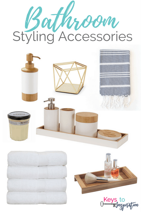A collection of bathroom styling accessories, including a soap dispenser, geometric candle holder, striped towel, scented candle, toiletries set on a tray, stack of white towels, and a wooden tray with toiletries. Modern pendant lights add a touch of elegance to complete the look. The text reads "Bathroom Styling Accessories".