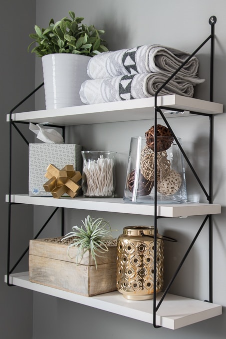 black accent wall shelves in powder room