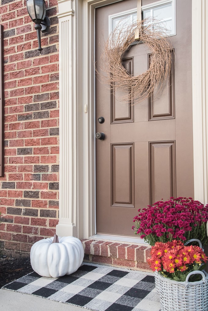 A simple and modern fall front porch. Decorate your front door for fall with gorgeous flowers and seasonal pumpkins.