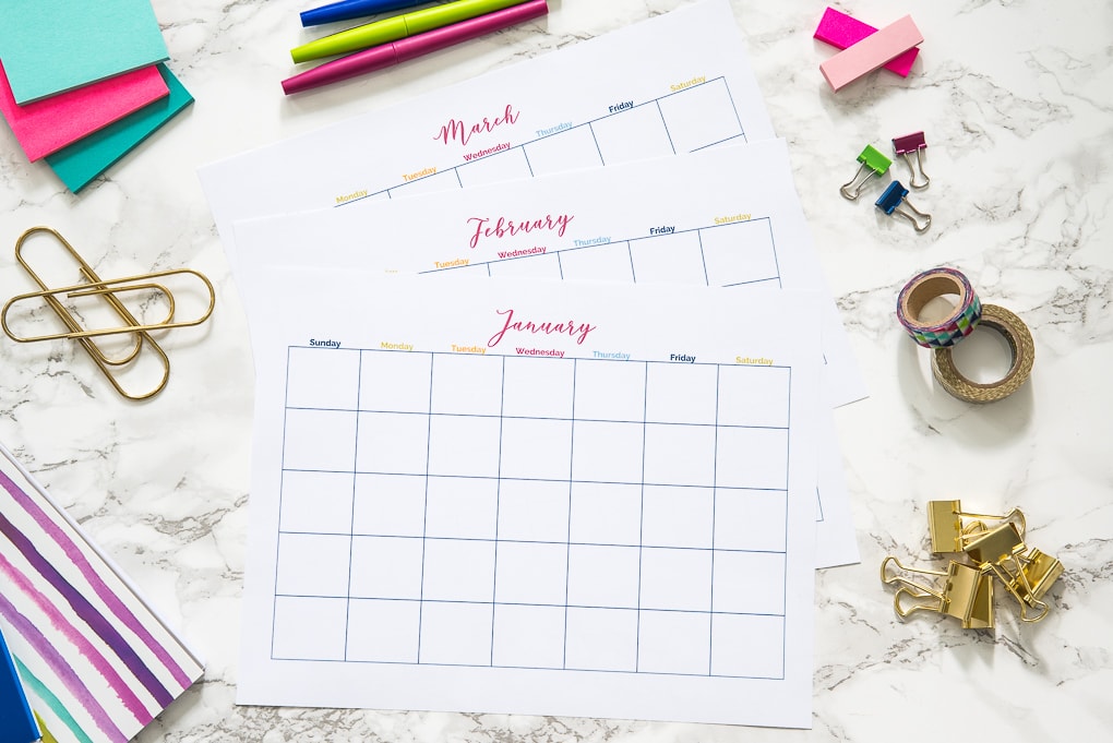 three months of printable calendars on a desk with office supplies