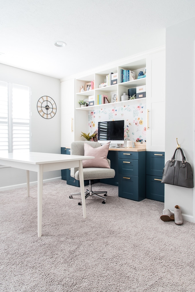 home office craft room built-in desk IKEA SEKTION cabinets pink pillow hanging purse and shoes