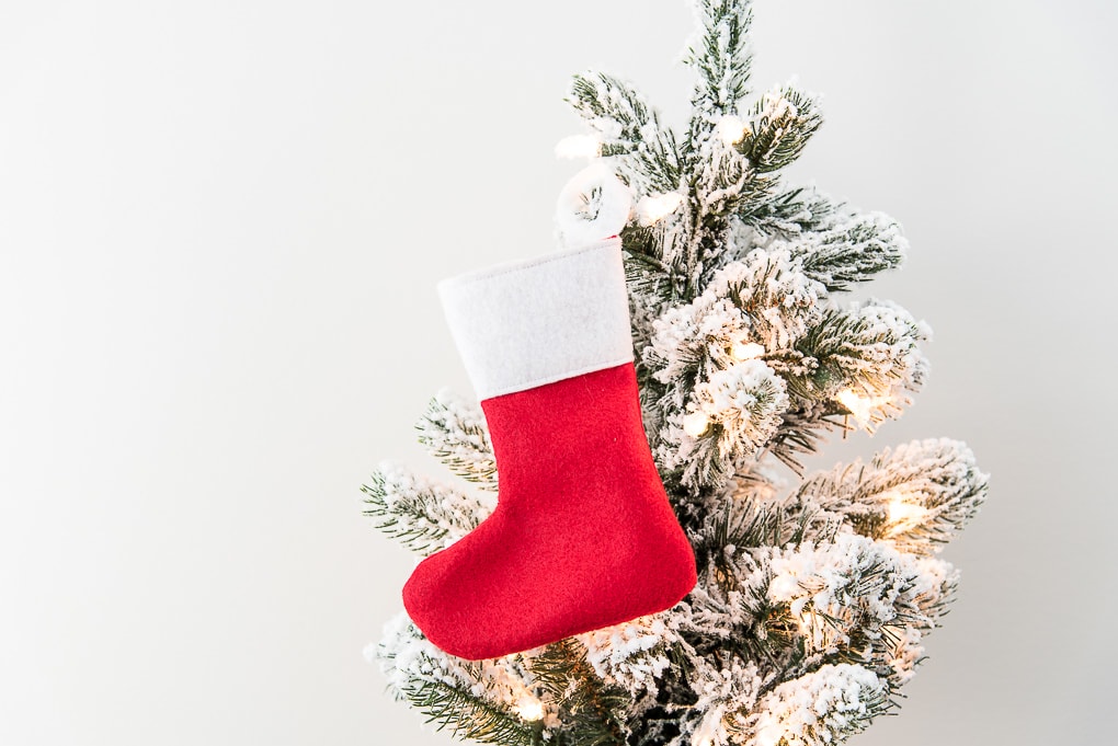 red and white mini felt stocking on flocked Christmas tree