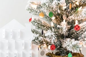 white advent calendar and colorful mini ornaments on flocked Christmas tree