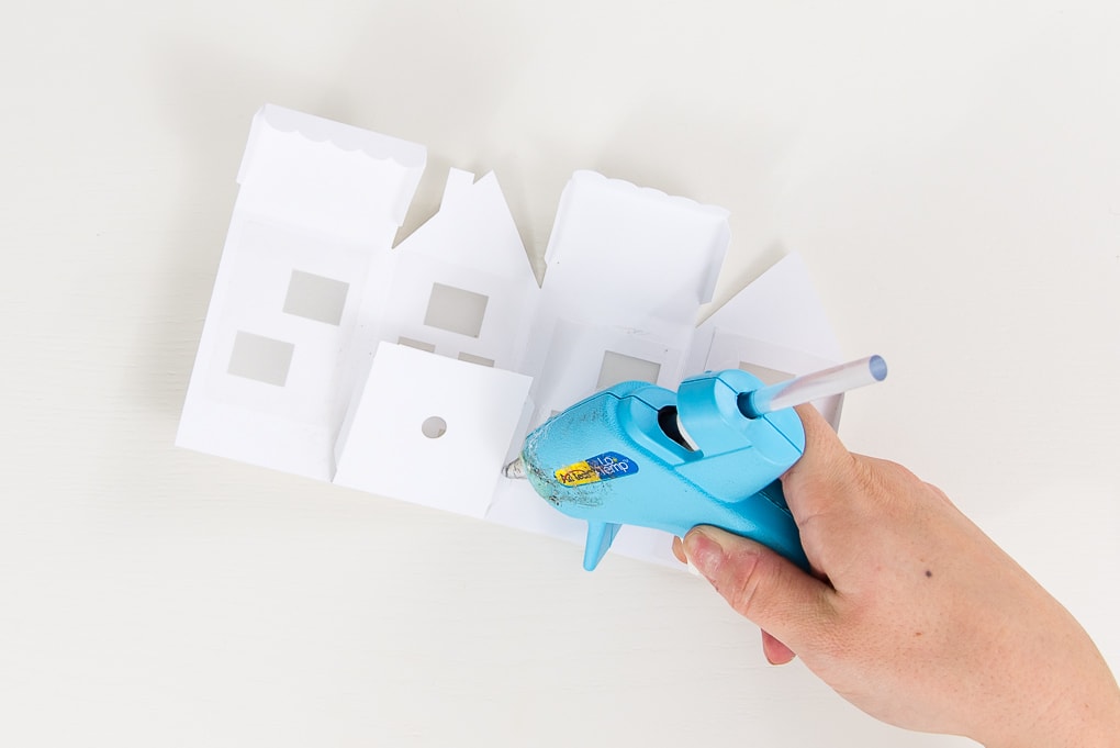 assembling paper 3D winter house with hot glue gun