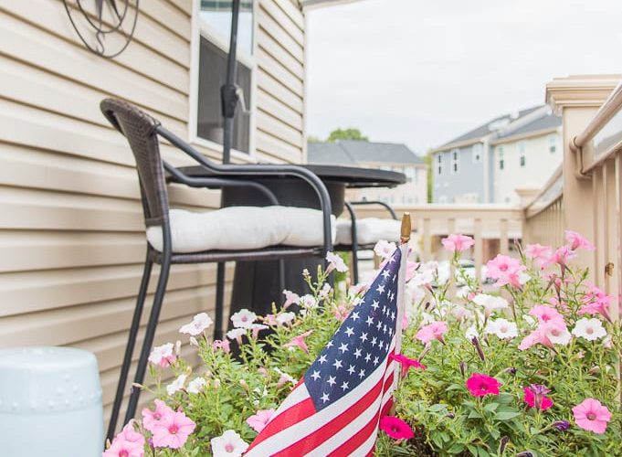 outdoor porch deck decorated for summer with flowers and American flag