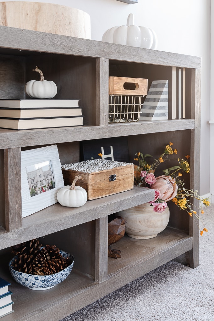 small white pumpkins on decorative bookshelves