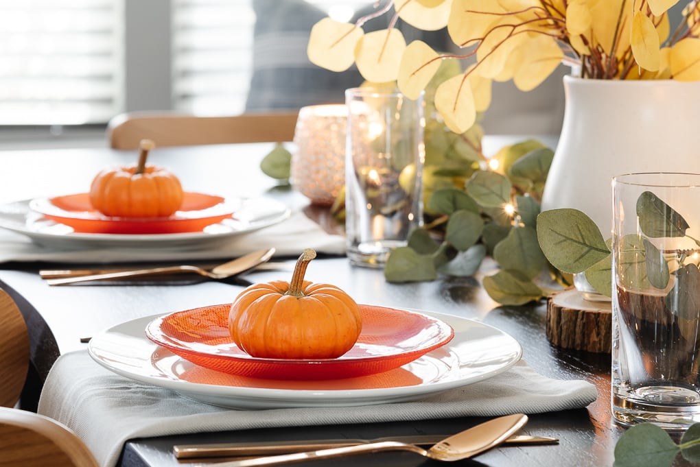 mini pumpkin on dinner plate on thanksgiving table