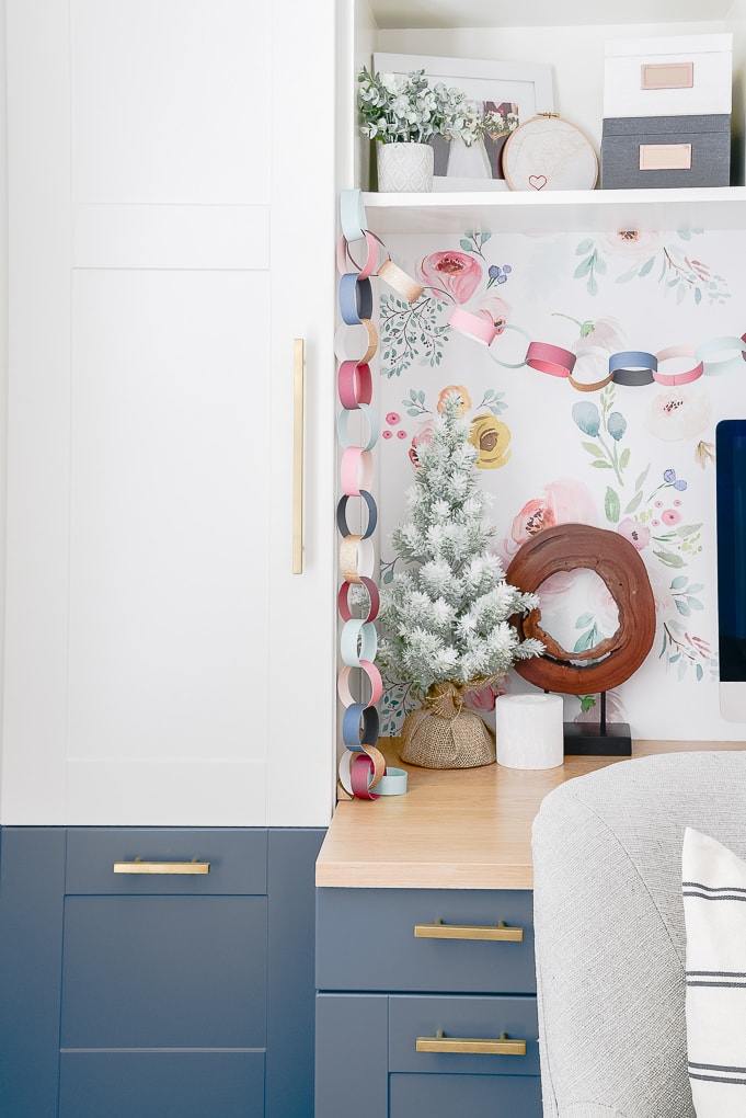 flocked tree on built in desk top with other colorful Christmas decorations