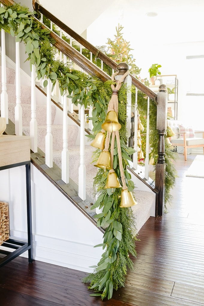 staircase with pine and eucalyptus Christmas garland and golden bells