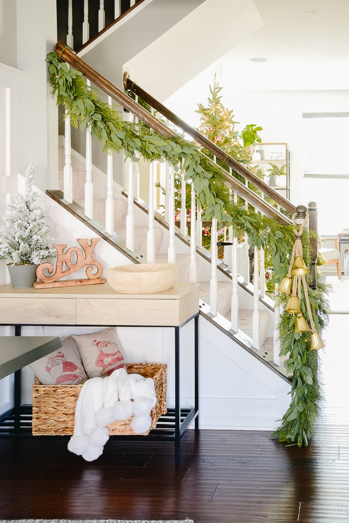 staircase with pine and eucalyptus Christmas garland and golden bells