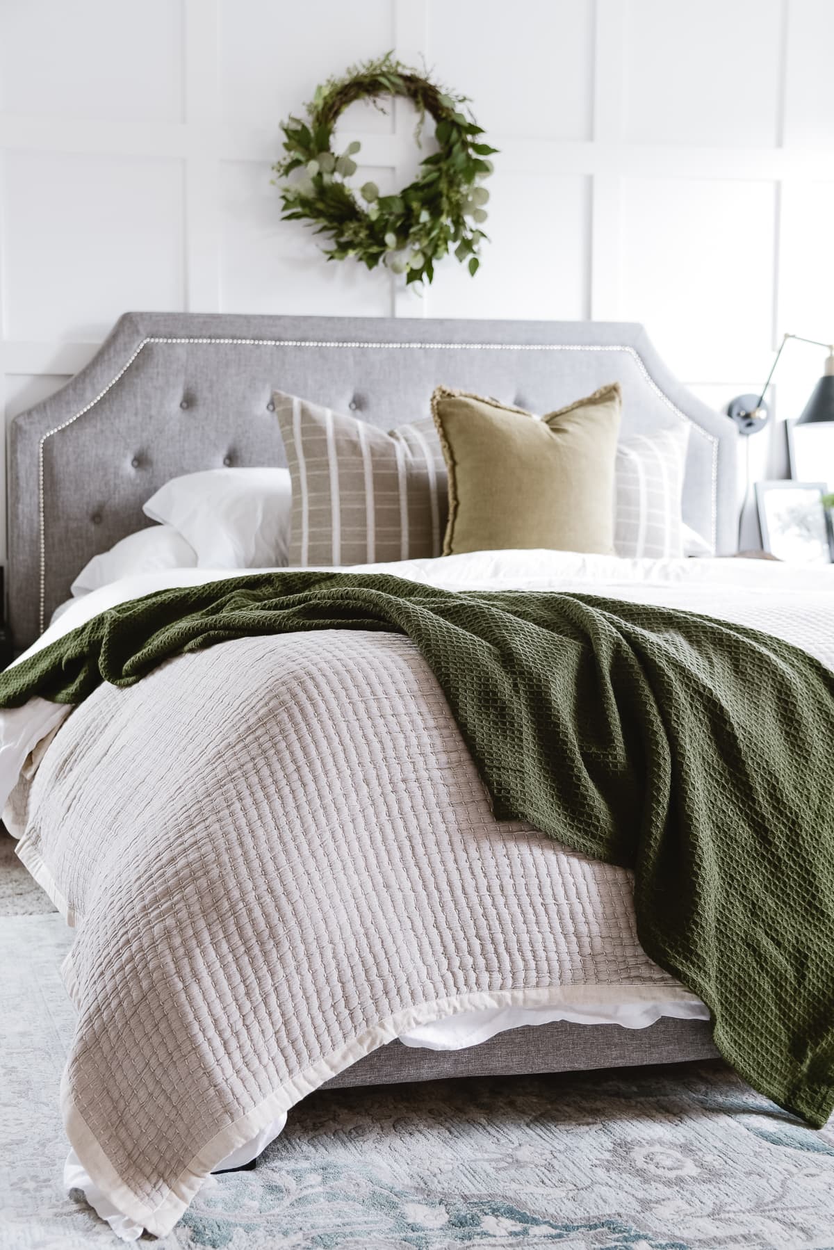 seasonal throw pillows in muted green on king bed
