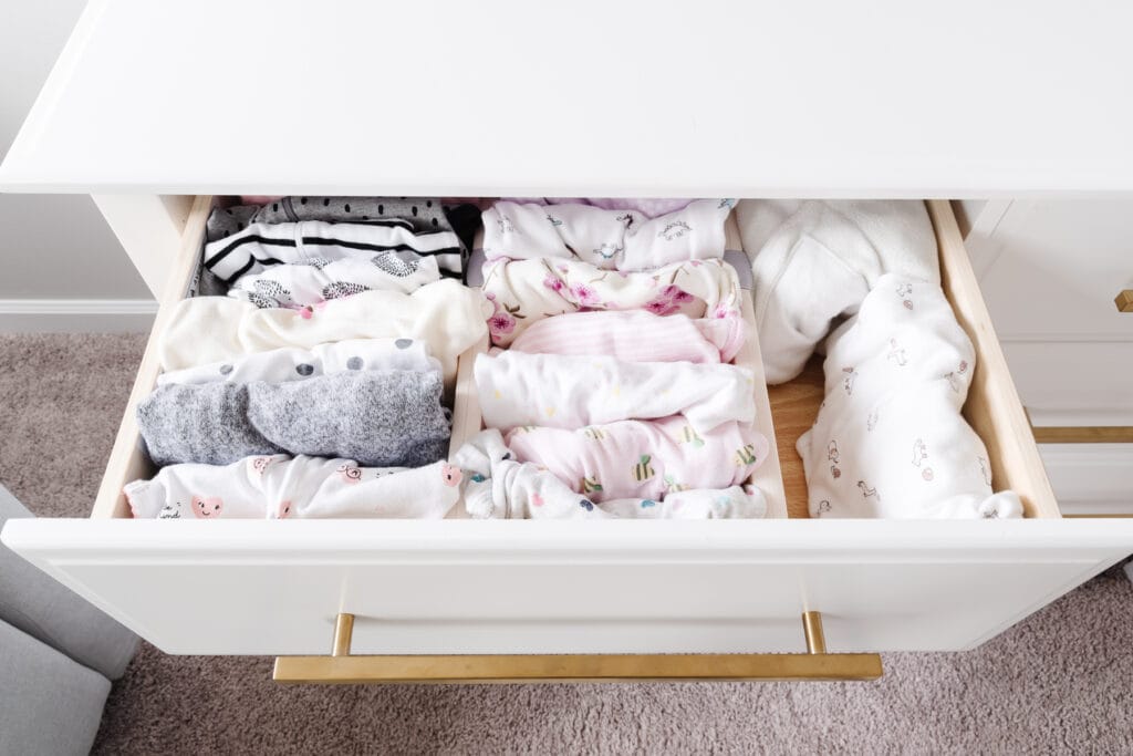 baby clothes in organized nursery dresser drawer